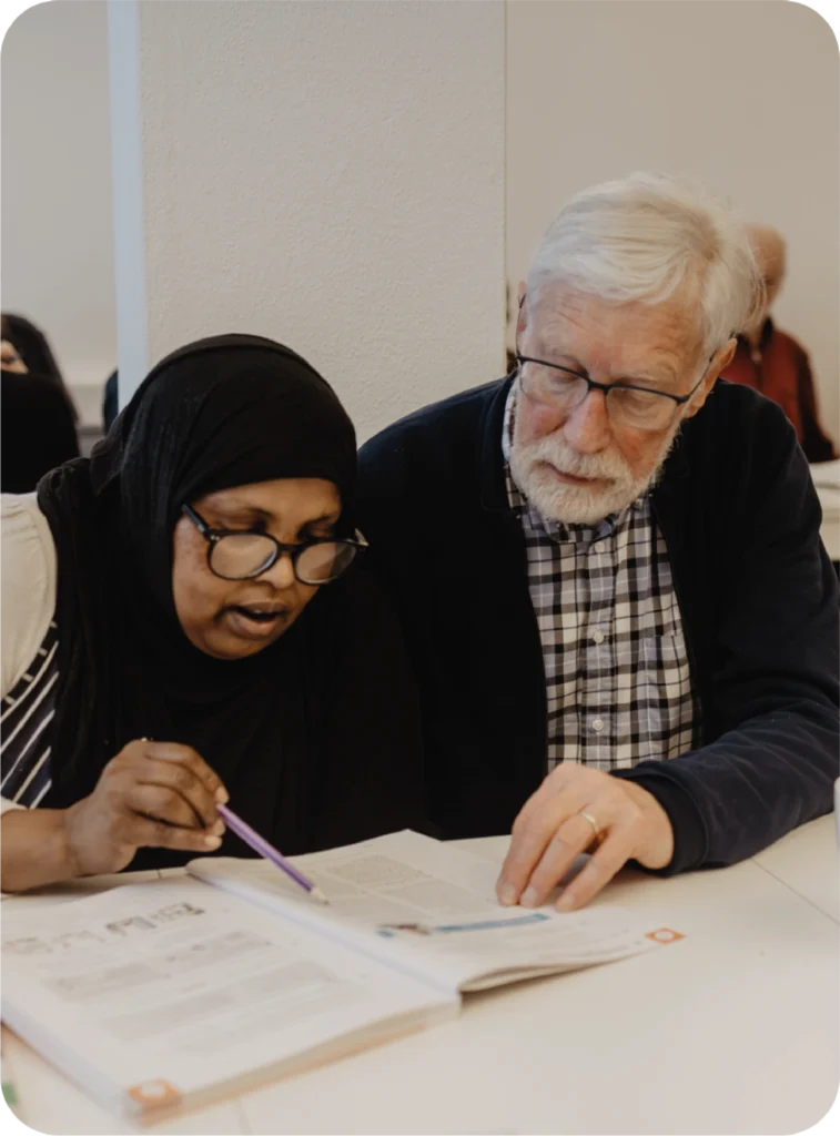 FLUX Hildesheim Mitarbeiter, welcher einer Frau das Lesen beibringt
