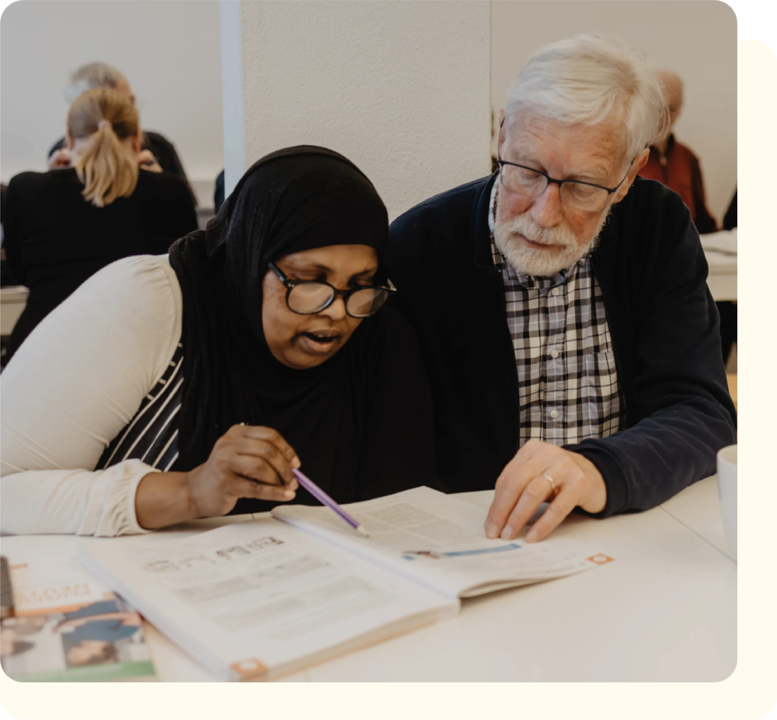 FLUX Hildesheim Mitarbeiter, welcher einer Frau das Lesen beibringt