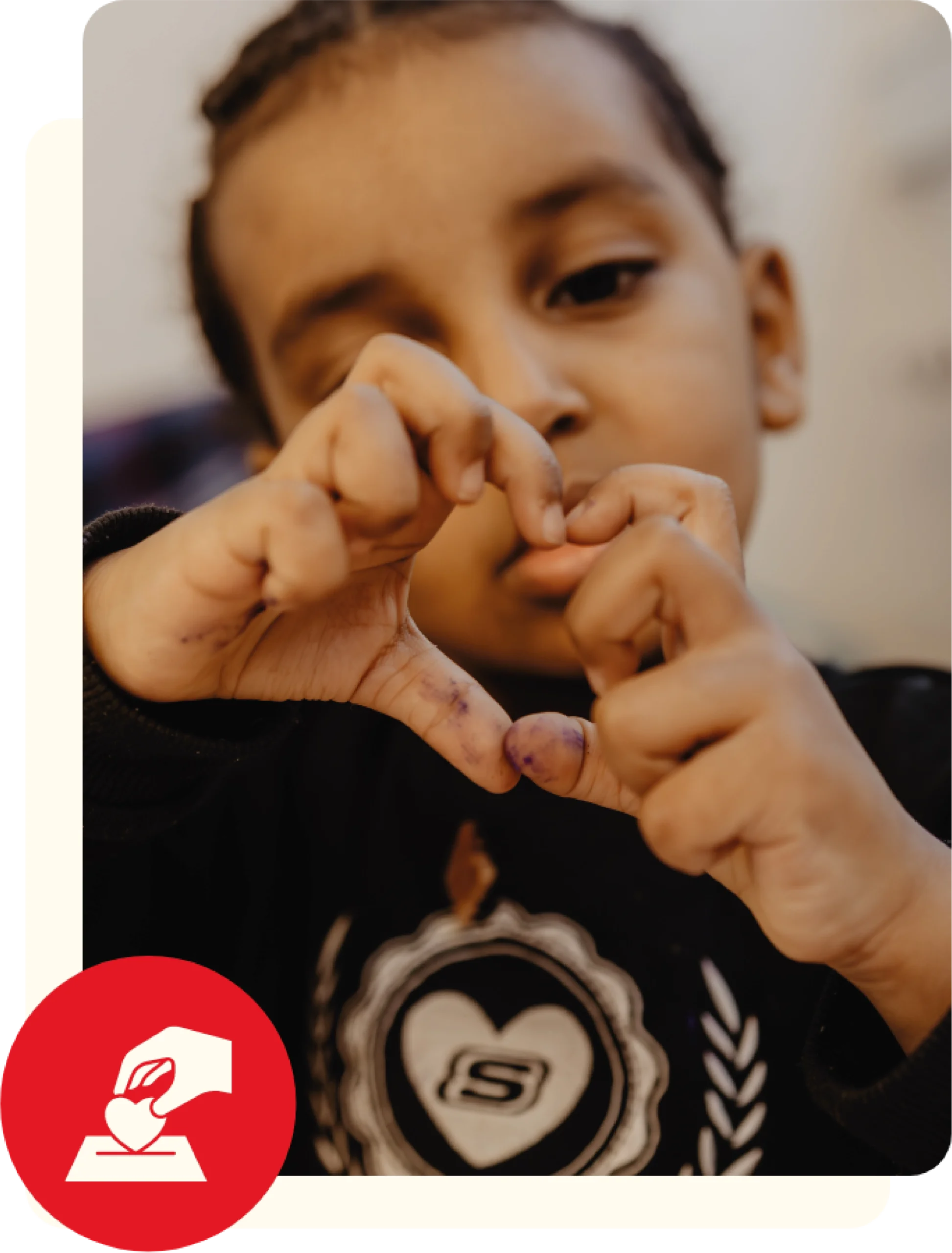 Kleiner Junge, welcher mit seinen Händen ein Herz formt