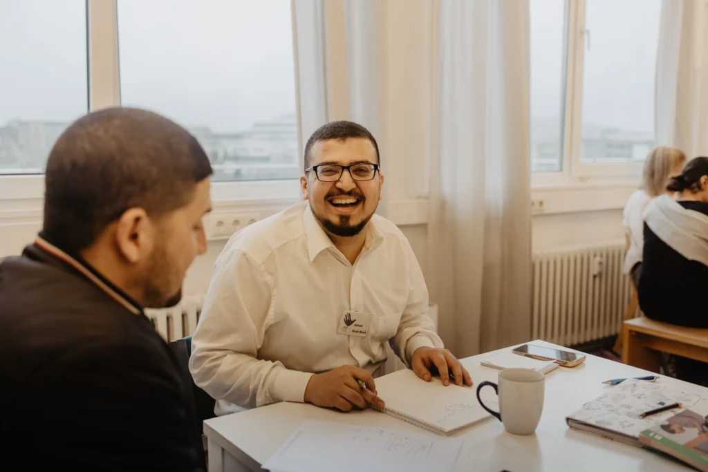 Lächelnder FLUX Hildesheim Mitarbeiter sitzend am Schreibtisch