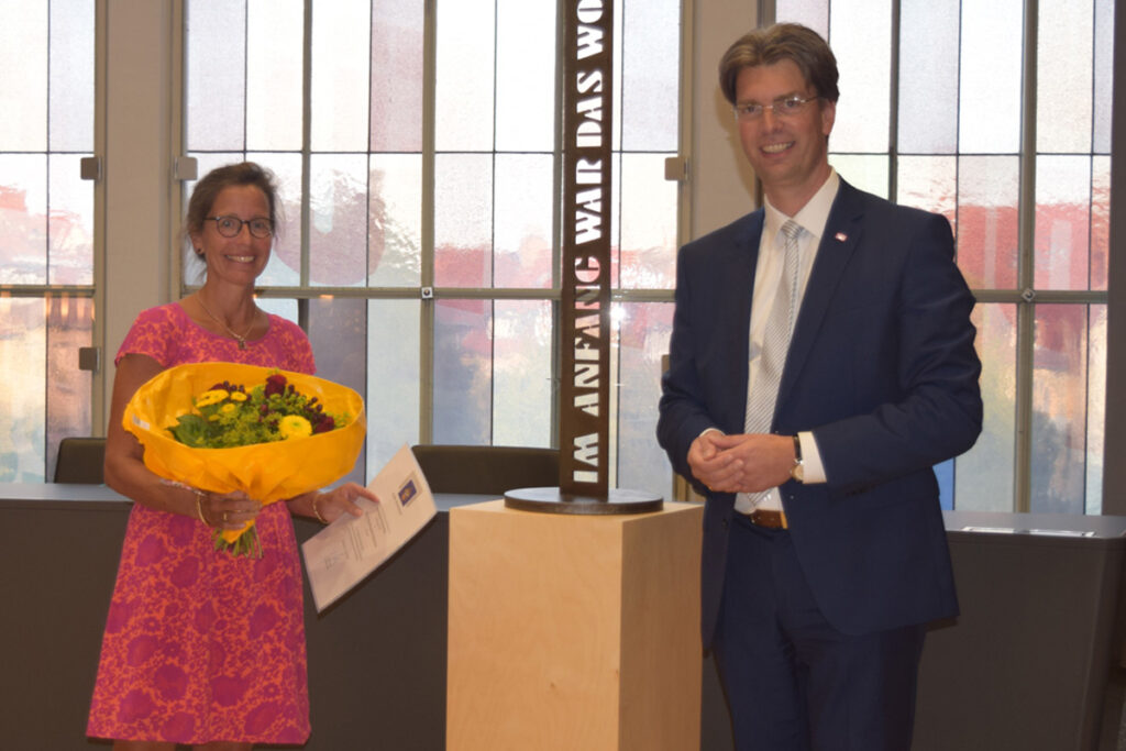 Bürgermeister der Stadt Hildesheim überreicht Marietta Tebbenjohanns von der FLUX Flüchtlingshilfe Blumen und den Hildesheimer Friedenspreis.